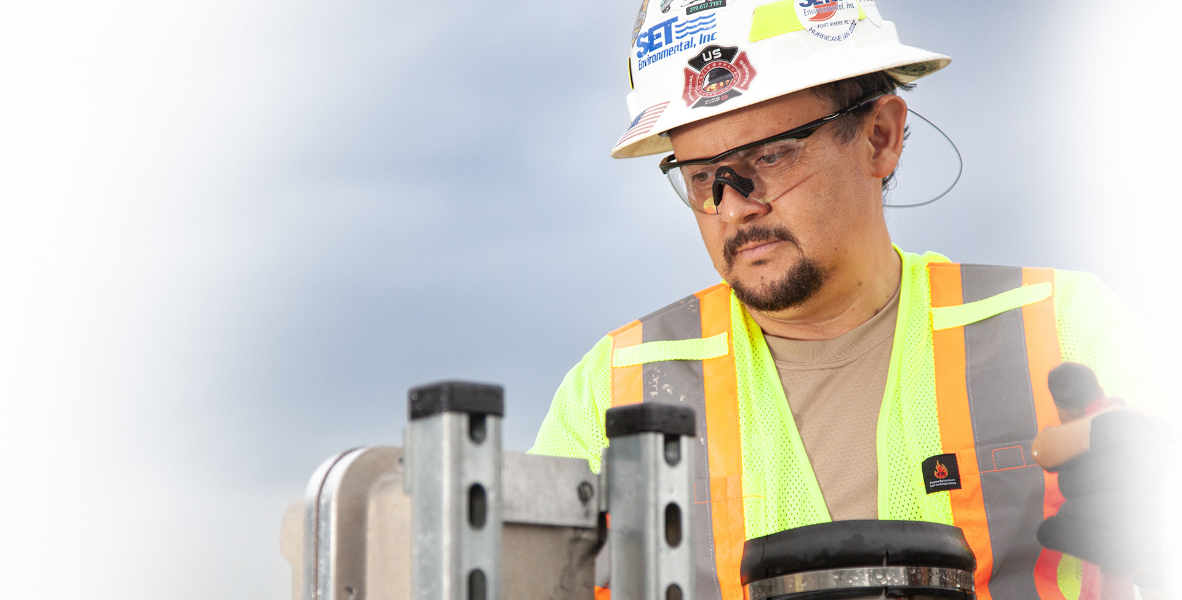 SET Environmental worker wearing safety hat, safety glasses, and safety vest