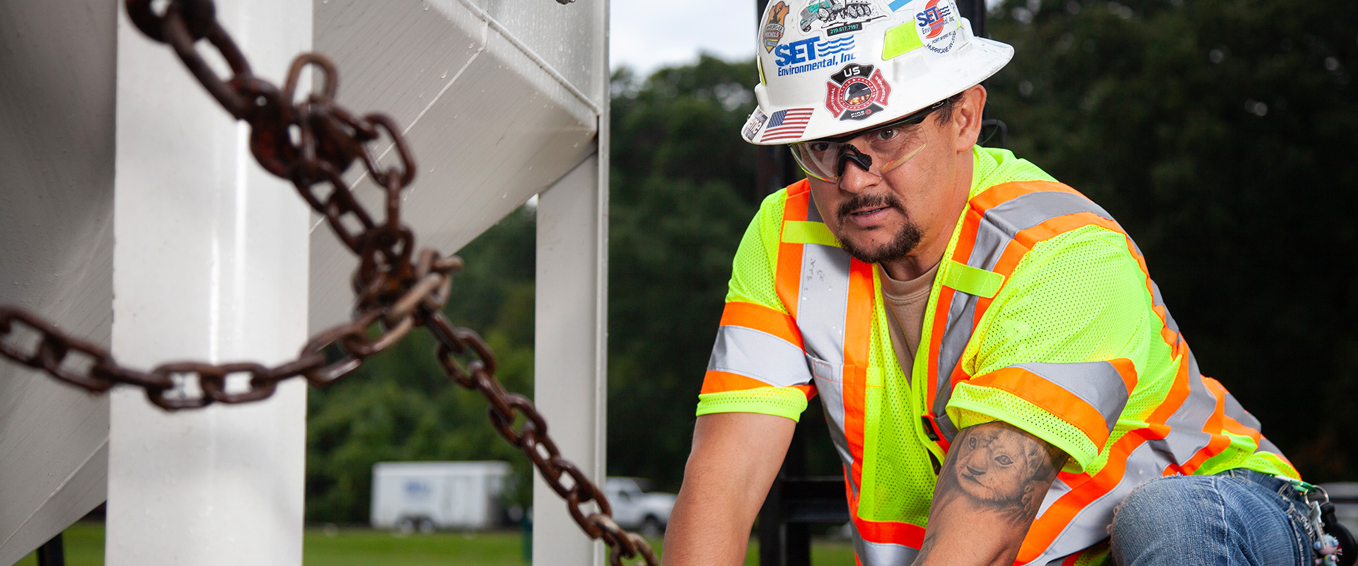 worker in a safety hat, safety glasses, and safety vest