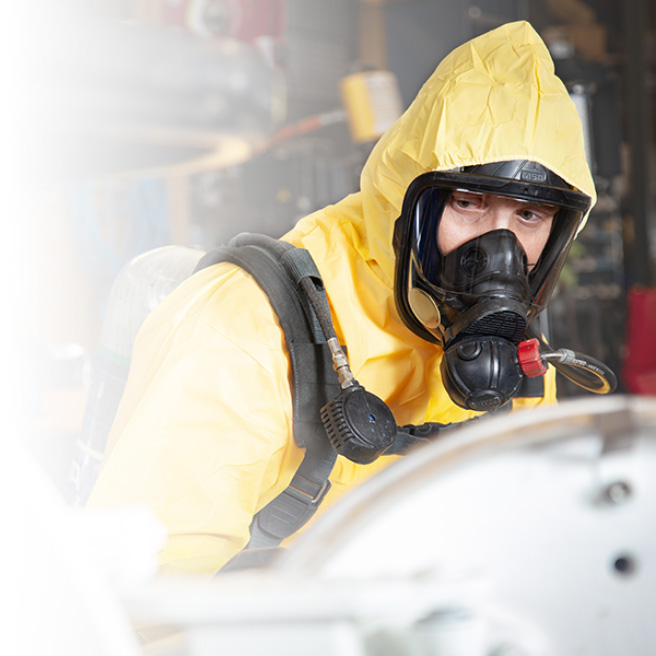 hazard waste management worker wearing yellow suit with oxygen mask