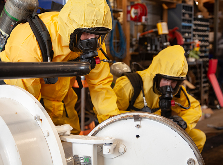 compressed gas recycle disposal workers geared up in yellow suits with oxygen masks