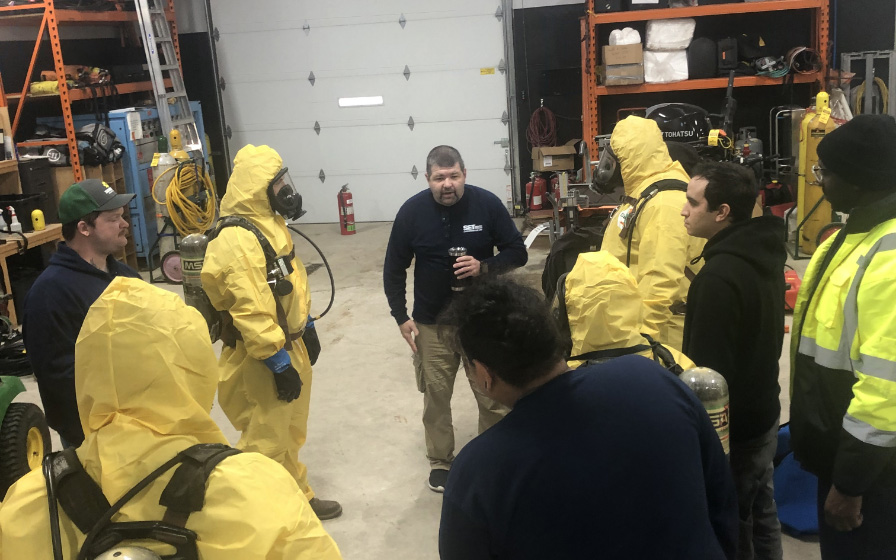 Safety training in yellow suits and oxygen masks